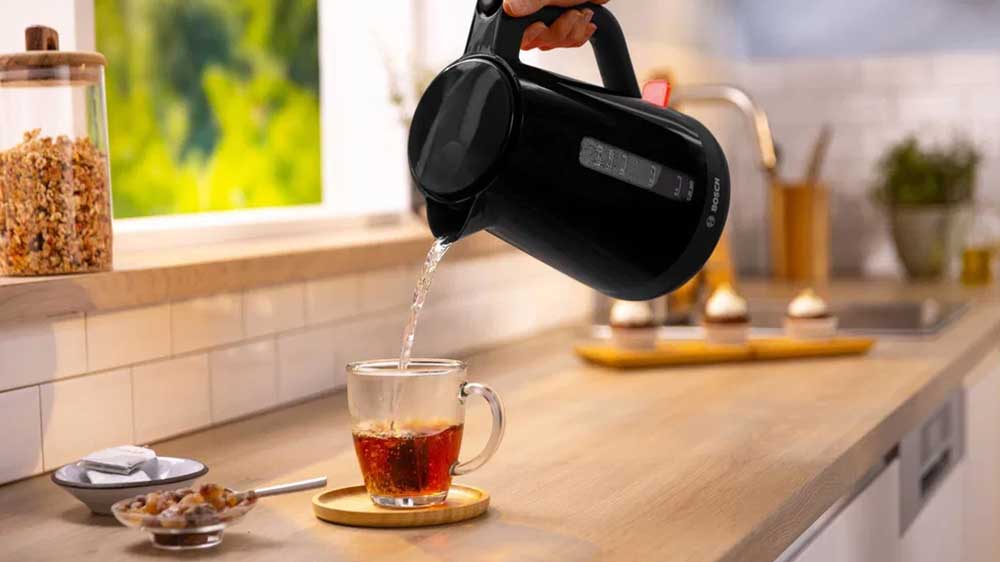 Pohled na pohodlné zalévání horkého nápoje z designové černé konvice Bosch