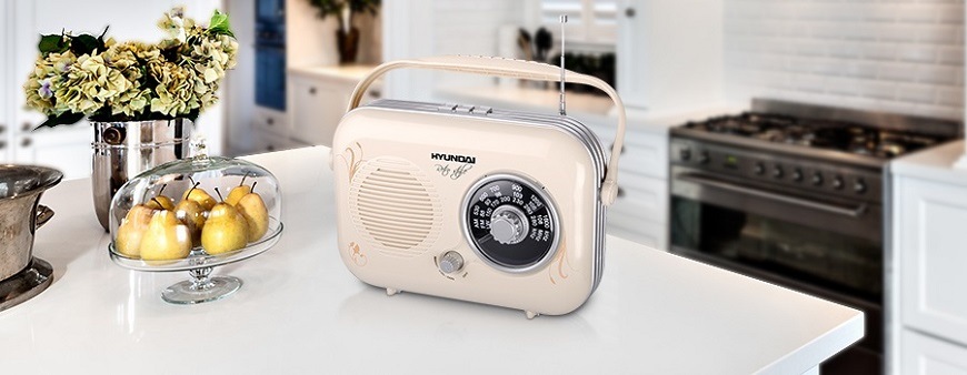Retro radiopřijímač Hyundai PR 100 v béžové barvě na dřevěném podkladu